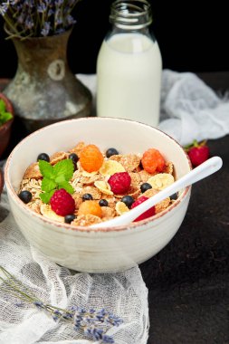 Sağlıklı vejetaryen kahvaltı. Yulaf ezmesi, granola ahududu ve yaban mersini kase üzerinde kahverengi zemin, buket lavanta ile. Üstten görünüm. Düz yatıyordu. 