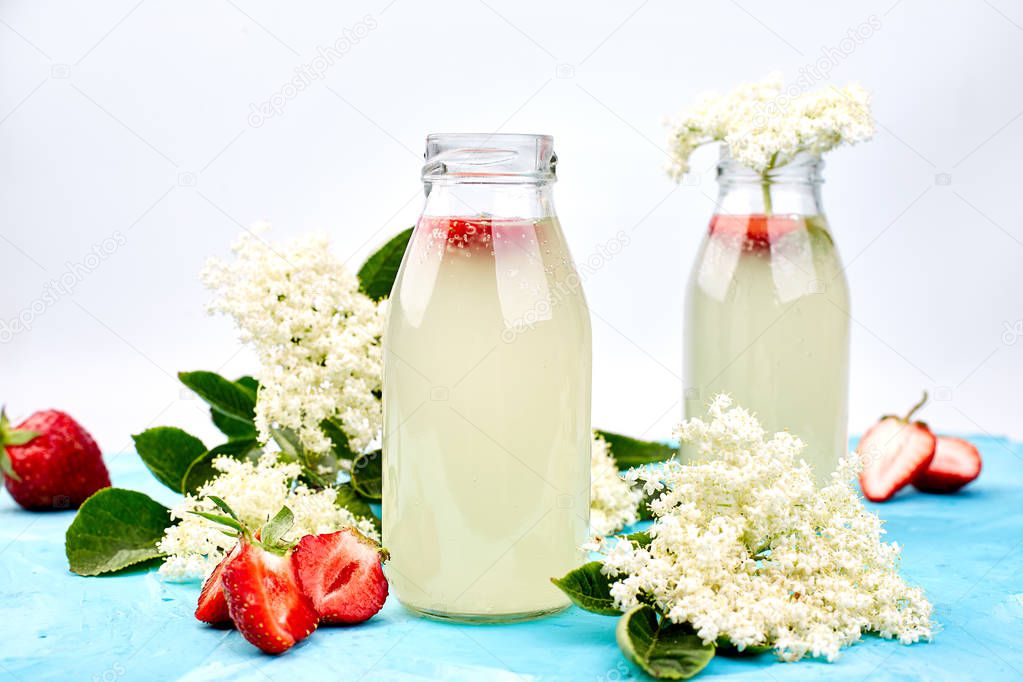 Kombucha tea with elderflower and strawberry on blue background. . Homemade fermented infused drink. Summer Healthy natural probiotic flavored drink. Copy spac