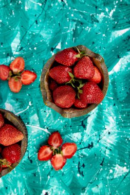 Yeşil bir arka plan üzerinde kase çilek. Düz yatıyordu. Üstten görünüm. Uzay kopyalayın. Sağlıklı taze meyve. Organik gıda. Açık gıda.