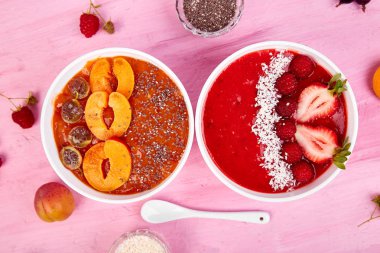 Güler yüzlü kase. Pembe bir arka plan üzerinde sağlıklı kahvaltı kase. Blackberry ve chia tohum ile kayısı güler yüzlü. Çilek ve Hindistan cevizi ile ahududu güler yüzlü. Vegan gıda. Üstten görünüm. Düz yatıyordu