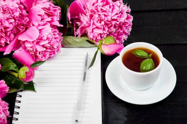Şakayık çiçekleri Not veya günlük ve kahve siyah zemin üzerine. Liste yapmak için planlama. Uzay kopyalayın. Boş boş. Kadın işyeri. Günaydın.