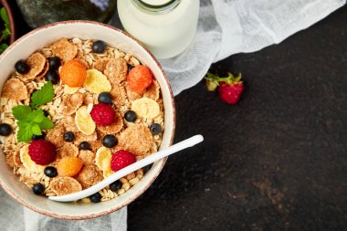 Sağlıklı vejetaryen kahvaltı. Yulaf ezmesi, granola ahududu ve yaban mersini kase üzerinde kahverengi zemin, buket lavanta ile. Üstten görünüm. Düz yatıyordu. 