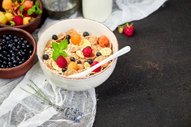 Sağlıklı vejetaryen kahvaltı. Yulaf ezmesi, granola ahududu ve yaban mersini kase üzerinde kahverengi zemin, buket lavanta ile. Üstten görünüm. Düz yatıyordu. 