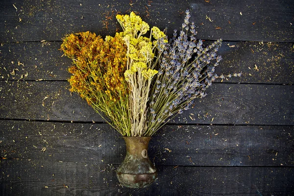 Dry herbs flower in vase - tutsan, sagebrush, oregano, helichrysum, lavender. Aromatherapy. Medicinal. Copy space Flat lay Top view