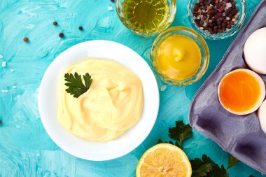 Ev yapımı Sos mayonez ve malzemeler yumurta, yağ, limon, mavi zemin üzerine mustar. Top vie