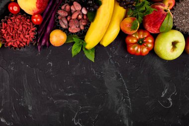 Sağlıklı renkli gıda seçimi: meyve, sebze, tohum, superfood, fasulye, koyu arka plan üzerinde yaprak sebze. Temiz yemek. Vejetaryen. Detoks. Süpermarket ürün yelpazesinde taze organik doğal kavramı 