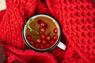 Kupa veya sıcak kartopu çay kırmızı sıcak örme eşarp ile sonbahar maple kırmızı yaprakları ve kartopu beyaz arka plan üzerinde meyveleri. Üstten görünüm. düz yatıyordu. kopya alanı. Kış. Noel. Soğuk sezon.