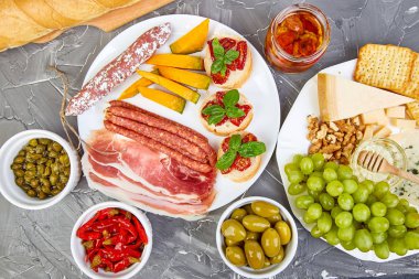 İtalyan antipasti şarap aperatifler küme. Meze tabağı pastırma, salam, peynir, üzüm, zeytin, turşu ile catering, Prosciutto di Parma ile kavun, grunge gri arka plan üzerinde Brushettas. İtalyan yemeği. Akdeniz. Teras yatıyordu. Kopya alanı. 