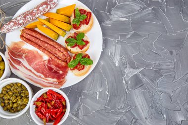 İtalyan antipasti şarap aperatifler küme. Meze tabağı pastırma, salam, peynir, üzüm, zeytin, turşu ile catering, Prosciutto di Parma ile kavun, grunge gri arka plan üzerinde Brushettas. İtalyan yemeği. Akdeniz. Teras yatıyordu. Kopya alanı. 