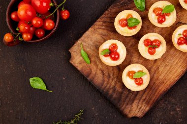 Mini tart kiraz domates ile ahşap tahta üzerinde mozzarella peyniri ile. Üstten görünüm. Uzay kopyalayın. Italyan Mutfagi