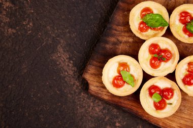 Mini tart kiraz domates ile ahşap tahta üzerinde mozzarella peyniri ile. Üstten görünüm. Uzay kopyalayın. Italyan Mutfagi