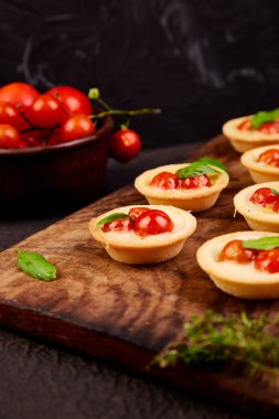 Mini tart kiraz domates ile ahşap tahta üzerinde mozzarella peyniri ile. Italyan Mutfagi