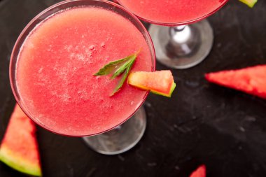 Siyah arka planda karpuz margarita kokteyli. Yaz partisi için naneli ve buzlu taze karpuz limonatası. Tazeleyici yaz içeceği. Üst görünüm.