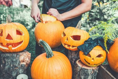 Jack-o-lantern erkek eli ile arka plan üzerinde bir kapak bir kabak dan keser. Cadılar Bayramı. Dekorasyon partisi için. Tonda fotoğraf.