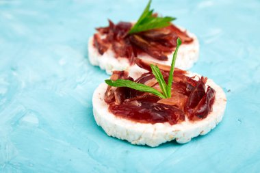 Pirinç crispbread ve mavi zemin üzerine taze meyve ile snack. Sağlıklı gıda kavramı. Yat, görünümü, yuvarlak top. Gevrek ekmek ile sağlıklı snack. Kolay meze tarifi.