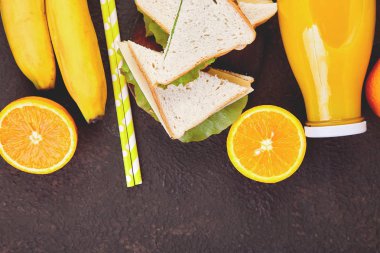 Kahverengi masa pikniğe. Kırmızı masa örtüsü, sepet, sağlıklı gıda sandviç ve meyve, portakal suyu kontrol ettim. Yaz Saati dinlenme. Düz yatıyordu