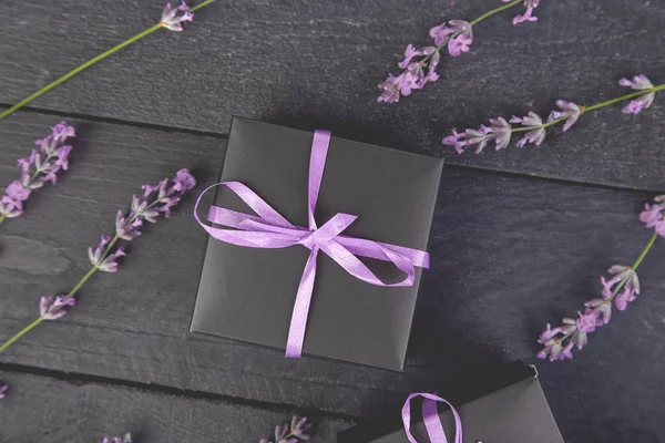 Czarne Pudełko Fioletowym Wstążki Bukiet Kwiatów Lawendy Czarnym Tle Uroczystości — Zdjęcie stockowe