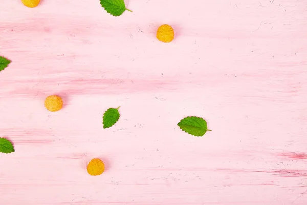 Flache Lagemuster Mit Gelben Himbeeren Und Minzblättern Auf Rosa Hintergrund — Stockfoto