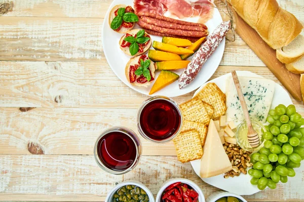 İtalyan antipasti şarap aperatifler küme. Meze tabağı pastırma, salam, peynir, üzüm, zeytin, turşu ile catering, Prosciutto di Parma ile kavun, grunge gri arka plan üzerinde Brushettas. İtalyan gıda maddeleri. Mediterranean 
