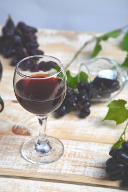 Şişe, cam ve ahşap arka plan üzerinde üzüm ile kırmızı şarap kavramı. Şarap başlık görüntü. Kadehlerin