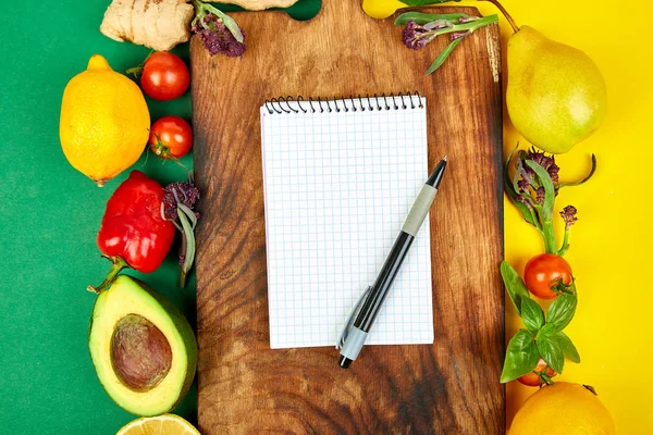 Shopping list, recipe book, diet plan. Fresh raw vegetables, fruit and  ingredients for healthy cooking. top view, place for text. Diet or vegan food, vegetarian and healthily cooking concept. Flat lay. Notepad for your recipe concept.