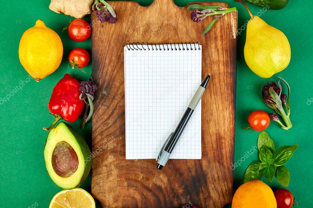 Shopping list, recipe book, diet plan. Fresh raw vegetables, fruit and  ingredients for healthy cooking. top view, place for text. Diet or vegan food, vegetarian and healthily cooking concept. Flat lay. Notepad for your recipe concept. 