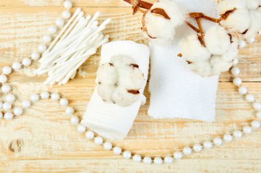 Pamuk bitki, kulaklı sopa, Pamuklu ped, havlu, kozmetik makyaj çıkarıcı tampon, hijyenik hijyenik temizleme bezi ahşap arka plan üstten görünüm üzerinde Şubesi. Spa kavramı. Düz yatıyordu. Kopya alanı.