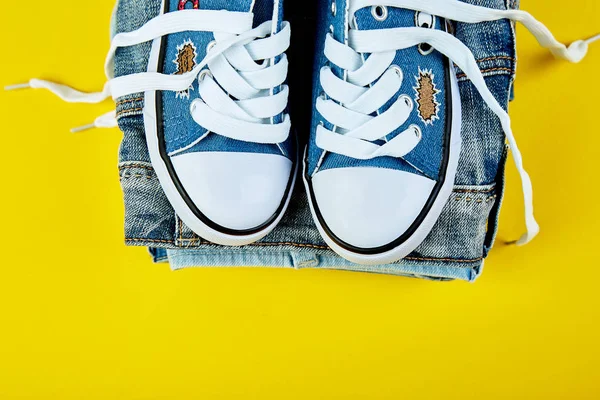 Blaue Weibliche Oder Männliche Turnschuhe Und Jeans Jeans Auf Gelbem — Stockfoto