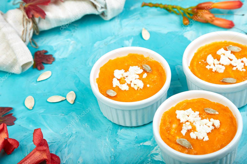 Cream of pumpkin soup or souffle on a blue background.  Thanksgiving Day. Diet vegetarian pupmkin soup puree. Copy space. 