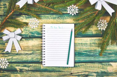 Çam dalları ve tatil dekorasyon yeşil rustik ahşap zemin üzerine listesi yapmak Noel. Üstten görünüm. Düz yatıyordu. Kopya alanı.