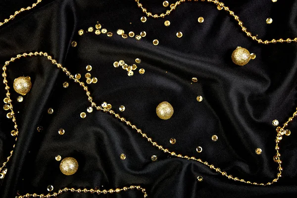 Luxury black background with gold  shiny balls. Christmas, birthday party. Flat lay. Copy space. Top view.w.