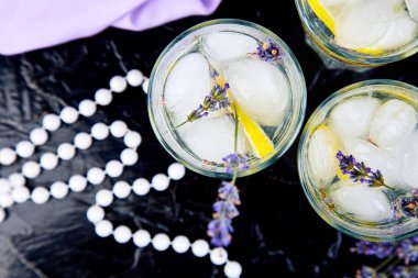 Lavanta Limonata limon ve siyah arka plan üzerine buz. Suyu detoks. Yaz içeceği. Diyet kokteyl. Güzel. Üstten görünüm. Kopya alanı.