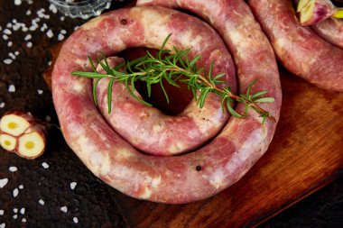 Biberiye, tuz ve peper ahşap kesme tahtası üzerinde ham sarmal domuz sosisi. Üstten Görünüm, metin için yer. Kopya alanı.