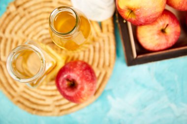 Organik elma sirkesi mavi zemin üzerine cam şişe. Elma sirkesi.