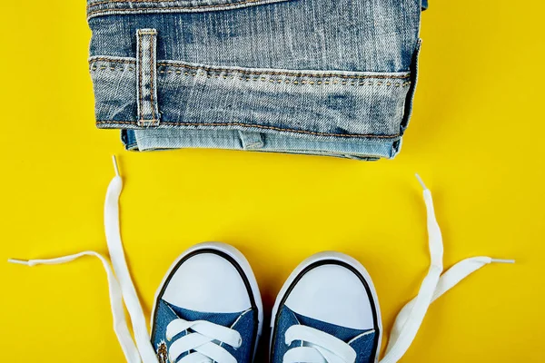 Blaue Weibliche Oder Männliche Turnschuhe Und Jeans Jeans Auf Gelbem — Stockfoto