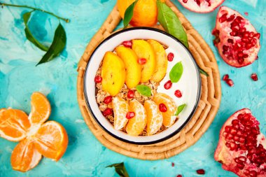 Tropikal smoothies meyve kahvaltı ev yapımı granola yoğurt nar, mandalina, Trabzon hurması mavi arka plan üzerinde top. sağlıklı organik katmanlı tatlı. Diyet, vegan gıda. Üstten görünüm