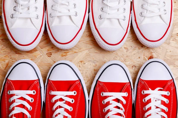 White and red sneakers on a the ripped denim background. Casual style items of men top view with copy space. Flat lay