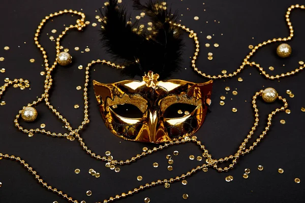 Black and gold carnival mask. Top view image of masquerade background. Flat lay. Mardi Gras celebration concept. Copy space.