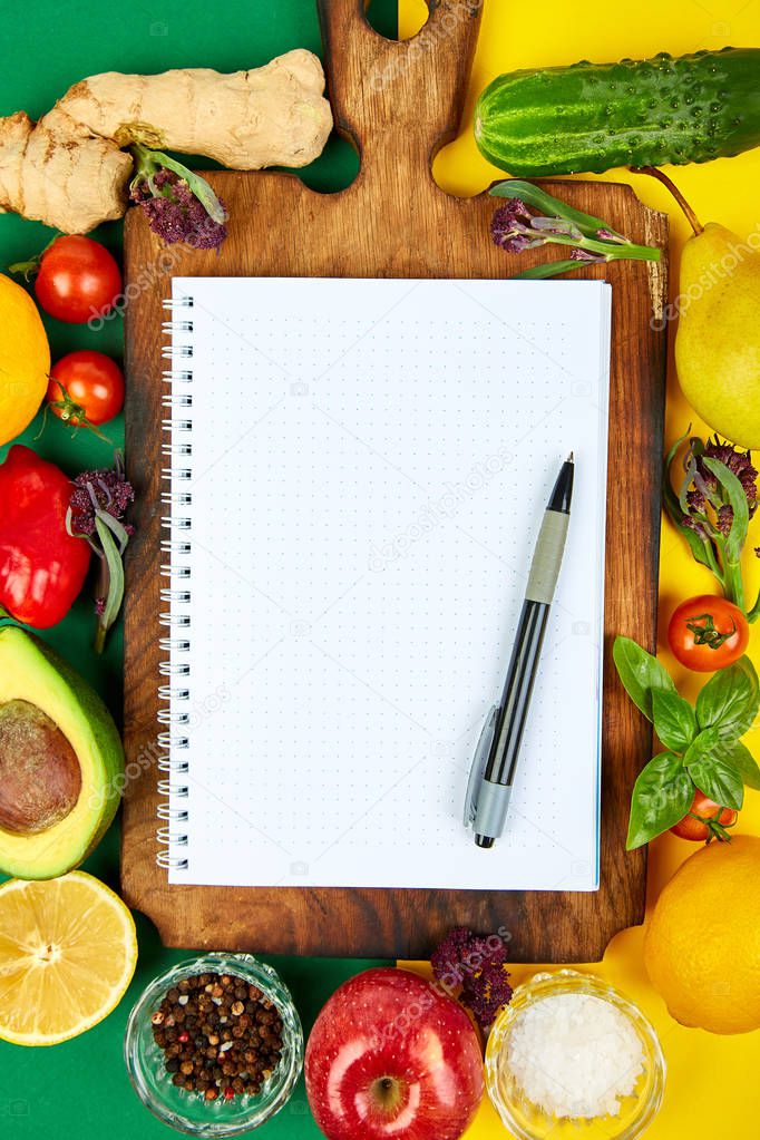 Shopping list, recipe book, diet plan. Fresh raw vegetables, fruit and  ingredients for healthy cooking. top view, place for text. Diet or vegan food, vegetarian and healthily cooking concept. Flat lay. Notepad for your recipe concept. 