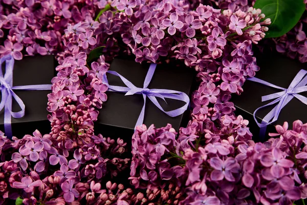 Черные Маленькие Подарочные Коробочки Обёрнутые Фиолетовой Фиолетовой Лентой Украшенные Цветком — стоковое фото