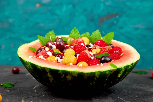 Watermelon bowl with cottage cheese and berries, apricot, raspberry, gooseberries