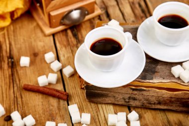 İki bardak kahve espresso yakınındaki rustik ahşap masa üzerinde küp şeker. 