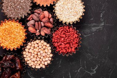 Çeşitli superfoods blackbackground üzerinde küçük kase. Superfood chia, ham kakao çekirdeği, goji, nohut, mercimek gibi. Uzay kopyalayın. Düz yatıyordu.