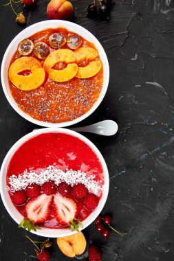 Güler yüzlü kase. Siyah arka plan üzerinde sağlıklı kahvaltı kase. Blackberry ve chia tohum ile kayısı güler yüzlü. Çilek ve Hindistan cevizi ile ahududu güler yüzlü. Vegan gıda. Üstten görünüm. Düz yatıyordu