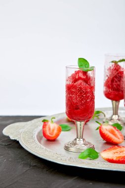 Çilek şerbetler serinletici yaz, granita içecek gözlük gümüş tepsi üzerinde hizmet içinde slush. Sağlıklı düşük kalorili yaz tedavi, tatlı. Siyah arka plan üzerine Buzlu kokteyli