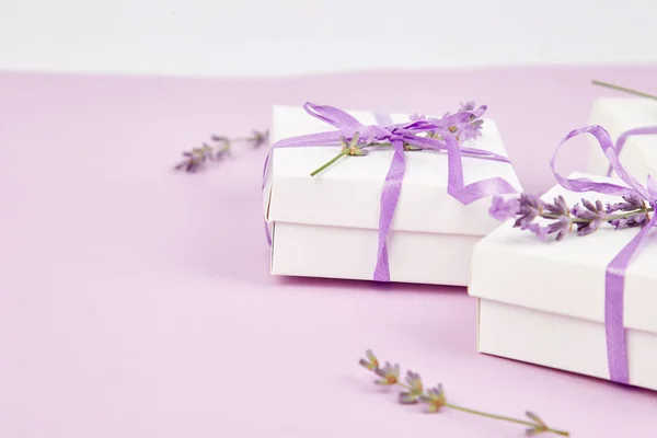 白色礼品盒与紫罗兰色带和花束的花薰衣草粉红色的背景 庆祝生日装饰礼品 复制空间 — 图库照片