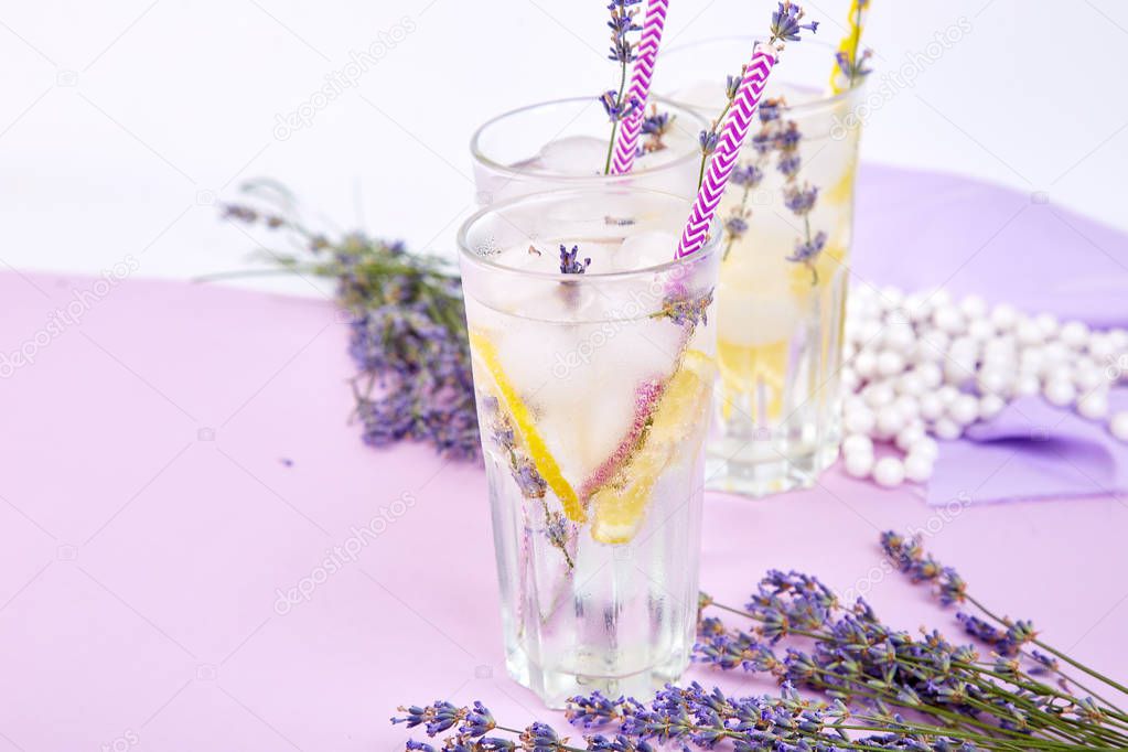 Lavender lemonade with lemon and ice on purple background. Detox water. Summer drink. Diet cocktail. Beautiful.