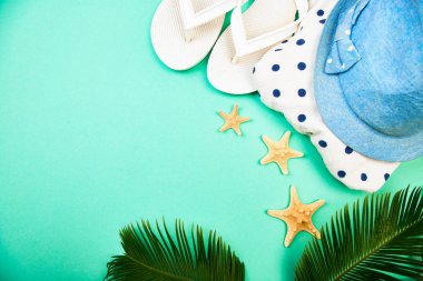 Yaz kadın moda kıyafet. Sunhat, beyaz flip flop, puantiyeli havlu ve denizyıldızı tropikal hurma dalları ile mavi arka plan üzerinde. Plaj, tatil, kavram, Minimalizm seyahat. Düz yatıyordu, en iyi görünüm. Kopya alanı.