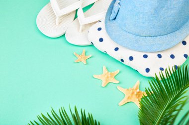 Yaz kadın moda kıyafet. Sunhat, beyaz flip flop, puantiyeli havlu ve denizyıldızı tropikal hurma dalları ile mavi arka plan üzerinde. Plaj, tatil, kavram, Minimalizm seyahat. Düz yatıyordu, en iyi görünüm. Kopya alanı.