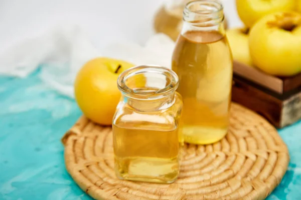 Organik elma sirkesi mavi zemin üzerine cam şişe. Elma sirkesi.